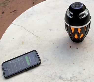 TikiTunes speaker on a table next to a phone playing music