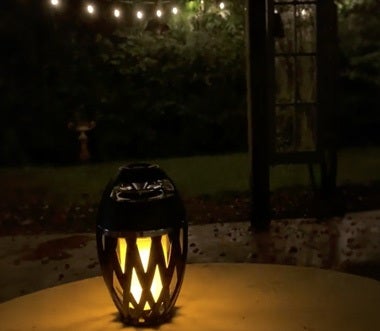 TikiTunes illuminated on a patio table at night